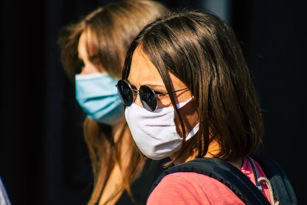 Fransa 'yı 12 Eylül 2020' de, Fransa 'nın Grand Est bölgesindeki bir şehir olan Reims sokaklarında yürüyen koronavirüsten kendilerini korumak için maske takan kimliği belirsiz yayalara bakıyor.