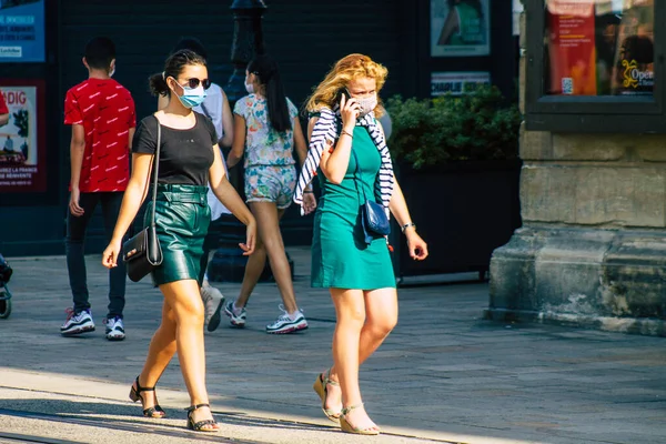 Fransa 'yı 12 Eylül 2020' de, Fransa 'nın Grand Est bölgesindeki bir şehir olan Reims sokaklarında yürüyen koronavirüsten kendilerini korumak için maske takan kimliği belirsiz yayalara bakıyor.