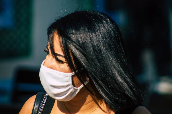 Fransa 'yı 12 Eylül 2020' de, Fransa 'nın Grand Est bölgesindeki bir şehir olan Reims sokaklarında yürüyen koronavirüsten kendilerini korumak için maske takan kimliği belirsiz yayalara bakıyor.