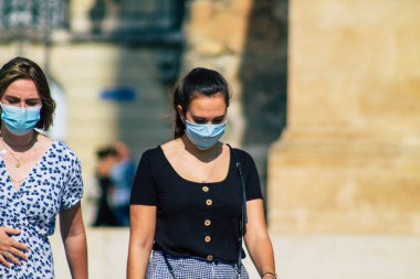 Fransa 'yı 15 Eylül 2020' de, Fransa 'nın Grand Est bölgesindeki bir şehir olan Reims sokaklarında yürüyen koronavirüsten kendilerini korumak için maske takan kimliği belirsiz yayalara bakıyor.