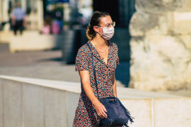 Fransa 'yı 15 Eylül 2020' de, Fransa 'nın Grand Est bölgesindeki bir şehir olan Reims sokaklarında yürüyen koronavirüsten kendilerini korumak için maske takan kimliği belirsiz yayalara bakıyor.