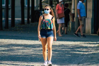 Fransa 'yı 15 Eylül 2020' de, Fransa 'nın Grand Est bölgesindeki bir şehir olan Reims sokaklarında yürüyen koronavirüsten kendilerini korumak için maske takan kimliği belirsiz yayalara bakıyor.