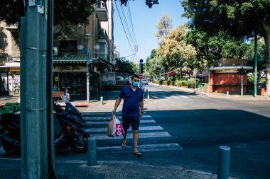 Tel Aviv İsrail 29 Eylül 2020 Coronavirus 'tan korunmak için yüzü maskeli kimliği belirsiz insanları tecrit ve Coronavirus salgını sırasında Tel Aviv' in boş sokaklarında yürürken görüyoruz.