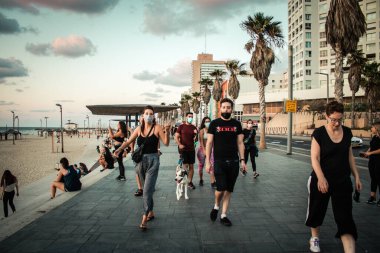 Tel Aviv İsrail, 4 Ekim 2020. Korunmak için maskesiz, kimliği belirsiz insanların Tel Aviv 'deki Herbert Samuel Promenade' de yürüşünü ve Coronavirus salgınını görüyoruz.
