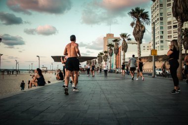 Tel Aviv İsrail, 4 Ekim 2020. Korunmak için maskesiz, kimliği belirsiz insanların Tel Aviv 'deki Herbert Samuel Promenade' de yürüşünü ve Coronavirus salgınını görüyoruz.