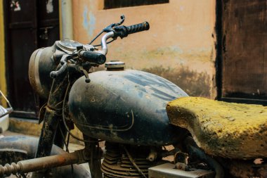 Şehir merkezinin caddelerinde yuvarlanan bir motorsikletin yakın çekimi.