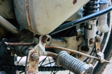 Şehir merkezinin caddelerinde yuvarlanan bir motorsikletin yakın çekimi.