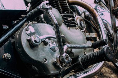 Şehir merkezinin caddelerinde yuvarlanan bir motorsikletin yakın çekimi.