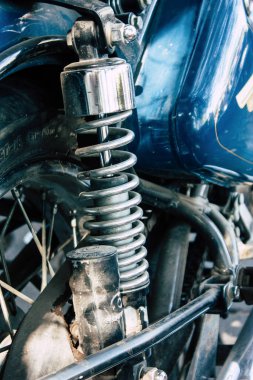 Şehir merkezinin caddelerinde yuvarlanan bir motorsikletin yakın çekimi.