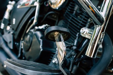 Şehir merkezinin caddelerinde yuvarlanan bir motorsikletin yakın çekimi.