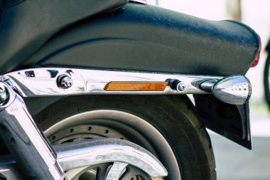 Şehir merkezinin caddelerinde yuvarlanan bir motorsikletin yakın çekimi.