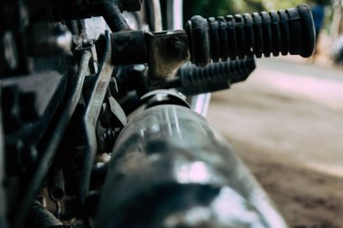 Şehir merkezinin caddelerinde yuvarlanan bir motorsikletin yakın çekimi.