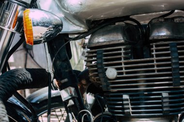 Şehir merkezinin caddelerinde yuvarlanan bir motorsikletin yakın çekimi.