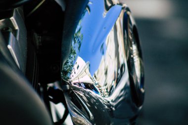 Şehir merkezinin caddelerinde yuvarlanan bir motorsikletin yakın çekimi.