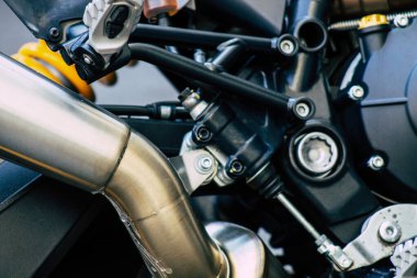 Şehir merkezinin caddelerinde yuvarlanan bir motorsikletin yakın çekimi.