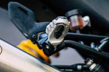 Şehir merkezinin caddelerinde yuvarlanan bir motorsikletin yakın çekimi.