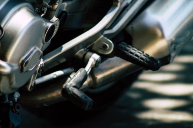 Şehir merkezinin caddelerinde yuvarlanan bir motorsikletin yakın çekimi.