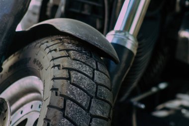 Şehir merkezinin caddelerinde yuvarlanan bir motorsikletin yakın çekimi.