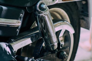 Şehir merkezinin caddelerinde yuvarlanan bir motorsikletin yakın çekimi.