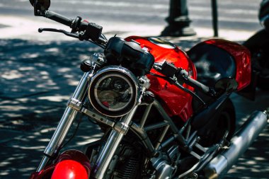 Şehir merkezinin caddelerinde yuvarlanan bir motorsikletin yakın çekimi.