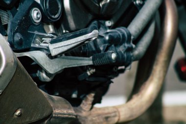 Şehir merkezinin caddelerinde yuvarlanan bir motorsikletin yakın çekimi.