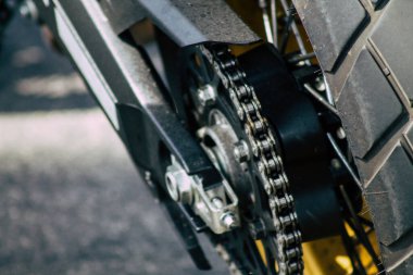 Şehir merkezinin caddelerinde yuvarlanan bir motorsikletin yakın çekimi.