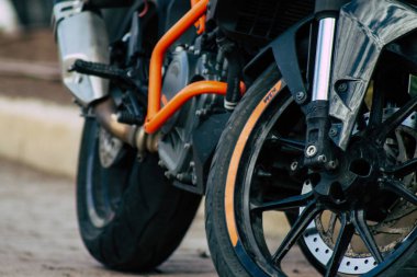 Şehir merkezinin caddelerinde yuvarlanan bir motorsikletin yakın çekimi.