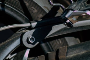 Şehir merkezinin caddelerinde yuvarlanan bir motorsikletin yakın çekimi.