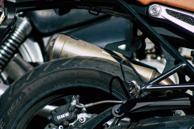 Şehir merkezinin caddelerinde yuvarlanan bir motorsikletin yakın çekimi.