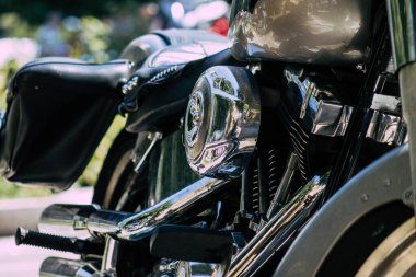 Şehir merkezinin caddelerinde yuvarlanan bir motorsikletin yakın çekimi.