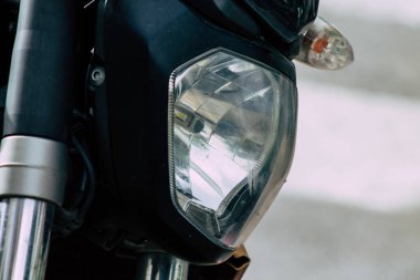 Şehir merkezinin caddelerinde yuvarlanan bir motorsikletin yakın çekimi.