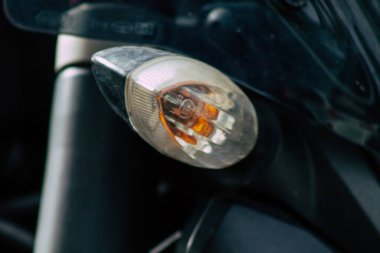 Şehir merkezinin caddelerinde yuvarlanan bir motorsikletin yakın çekimi.