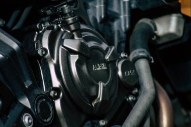 Şehir merkezinin caddelerinde yuvarlanan bir motorsikletin yakın çekimi.