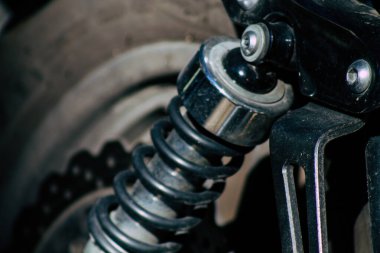 Şehir merkezinin caddelerinde yuvarlanan bir motorsikletin yakın çekimi.