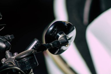 Şehir merkezinin caddelerinde yuvarlanan bir motorsikletin yakın çekimi.