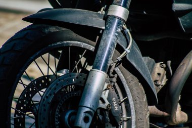 Şehir merkezinin caddelerinde yuvarlanan bir motorsikletin yakın çekimi.