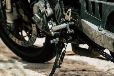 Şehir merkezinin caddelerinde yuvarlanan bir motorsikletin yakın çekimi.