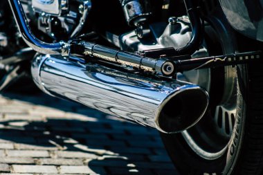 Şehir merkezinin caddelerinde yuvarlanan bir motorsikletin yakın çekimi.