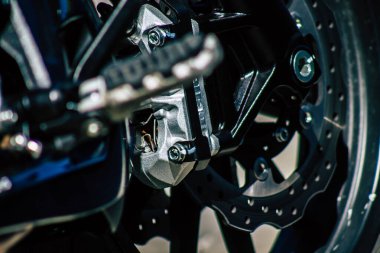 Şehir merkezinin caddelerinde yuvarlanan bir motorsikletin yakın çekimi.