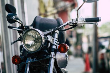 Şehir merkezinin caddelerinde yuvarlanan bir motorsikletin yakın çekimi.