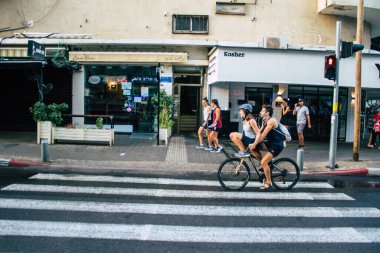 Tel Aviv İsrail 10 Ekim 2020 Coronavirus 'u korumak için yüzü maskeli kimliği belirsiz bir insanın tecrit ve Coronavirus salgını sırasında Tel Aviv' in boş sokaklarında yuvarlanışını izliyoruz.