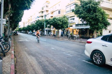 Tel Aviv İsrail 10 Ekim 2020 Coronavirus 'u korumak için yüzü maskeli kimliği belirsiz bir insanın tecrit ve Coronavirus salgını sırasında Tel Aviv' in boş sokaklarında yuvarlanışını izliyoruz.