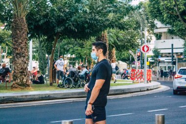 Tel Aviv İsrail 14 Ekim 2020 Coronavirus salgını sırasında yüz maskesi takmış kimliği belirsiz insanların sokaklarda yürüyüşü ve nüfusu kontrol altına almak için kilit altına alınması.