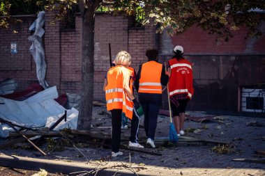 Kharkiv, Ukrayna, 16 Eylül 2025 Temizlik işçileri, Rus Şahin İHA 'sının bir binaya çarptığı sokakta karşılık veriyor. Hasar büyüktü ve bina alev aldı..