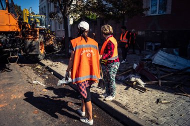 Kharkiv, Ukrayna, 16 Eylül 2025 Temizlik işçileri, Rus Şahin İHA 'sının bir binaya çarptığı sokakta karşılık veriyor. Hasar büyüktü ve bina alev aldı..