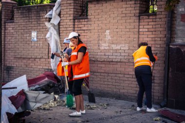 Kharkiv, Ukrayna, 16 Eylül 2025 Temizlik işçileri, Rus Şahin İHA 'sının bir binaya çarptığı sokakta karşılık veriyor. Hasar büyüktü ve bina alev aldı..