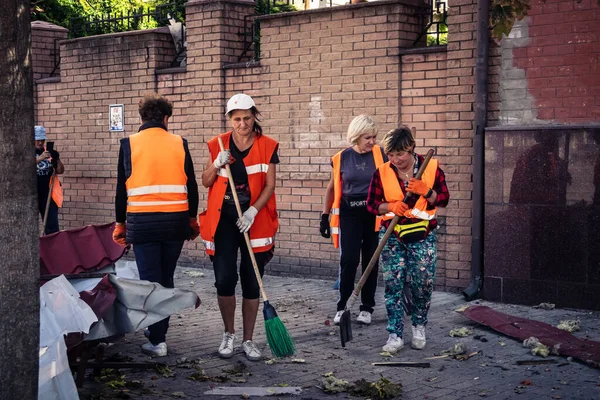 Kharkiv, Ukrayna, 16 Eylül 2025 Temizlik işçileri, Rus Şahin İHA 'sının bir binaya çarptığı sokakta karşılık veriyor. Hasar büyüktü ve bina alev aldı..