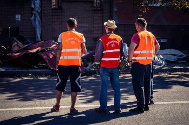 Kharkiv, Ukrayna, 16 Eylül 2025 Temizlik işçileri, Rus Şahin İHA 'sının bir binaya çarptığı sokakta karşılık veriyor. Hasar büyüktü ve bina alev aldı..
