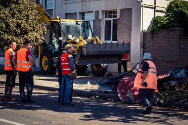 Kharkiv, Ukrayna, 16 Eylül 2025 Temizlik işçileri, Rus Şahin İHA 'sının bir binaya çarptığı sokakta karşılık veriyor. Hasar büyüktü ve bina alev aldı..