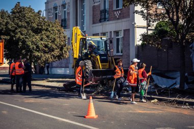 Kharkiv, Ukrayna, 16 Eylül 2025 Temizlik işçileri, Rus Şahin İHA 'sının bir binaya çarptığı sokakta karşılık veriyor. Hasar büyüktü ve bina alev aldı..